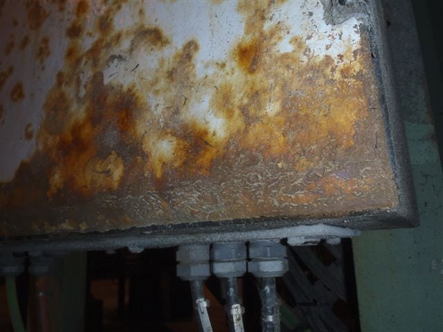 Rusty metal panel with wires attached, showcasing MetalTreat® Lanolin Corrosion Inhibitor in Action.